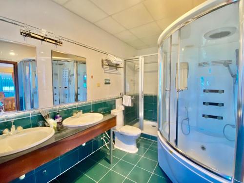 a bathroom with two sinks and a shower and a toilet at Don Bosco Hotel School in Sihanoukville