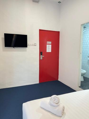 a red door in a room with a towel on a bed at The Harbour by Moonknight in George Town
