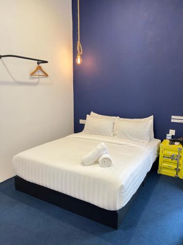 a bedroom with a large white bed with a purple wall at The Harbour by Moonknight in George Town