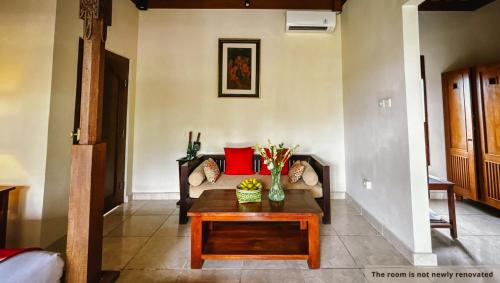 a living room with a couch and a coffee table at Svarga Bebek Villas in Ubud