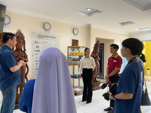 a group of people standing in a room with a person in a cape at Don Bosco Hotel School in Sihanoukville
