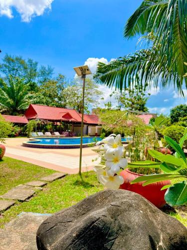 a rock with flowers on it next to a pool at Don Bosco Hotel School in Sihanoukville