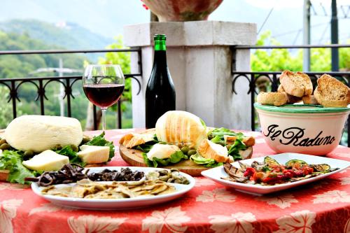 a table topped with plates of food and a glass of wine at Il Raduno in Tramonti