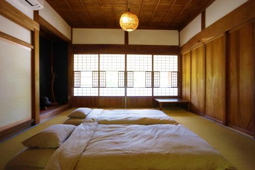 a large bed in a room with a large window at 農ある暮らしの宿古民家天地 in Minamiizu