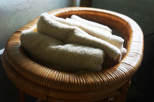 a wicker basket with a pile of towels in it at 農ある暮らしの宿古民家天地 in Minamiizu