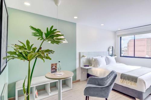 a bedroom with a bed and a table and a plant at Premium Loft in Bogota in Bogotá