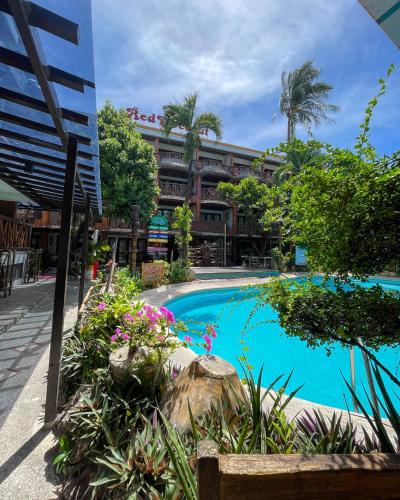 a resort with a swimming pool in front of a building at Red Coconut Beach Hotel Boracay in Boracay