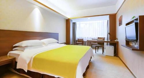 a hotel room with a large bed and a table at My Pleasant Hotel in Shenzhen