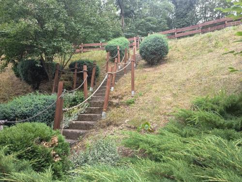 a set of stairs leading up a hill with a fence at HamvasDomb Vendégház in Egerszalók