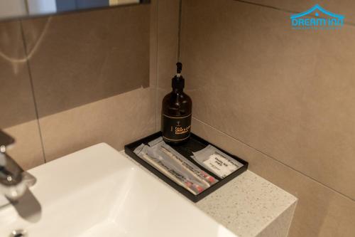 a bottle of alcohol sitting on top of a bathroom sink at Paxtonz Empire City Damansara Petaling Jaya by Dream Inn in Petaling Jaya