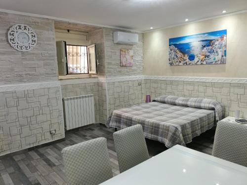 a room with two beds and a table and chairs at TIVA' Holiday House in Pozzuoli