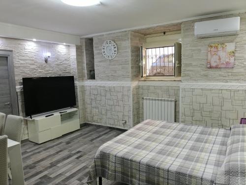a bedroom with a flat screen tv and a bed at TIVA' Holiday House in Pozzuoli