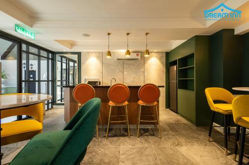a kitchen with orange chairs and a bar in a restaurant at Paxtonz Empire City Damansara Petaling Jaya by Dream Inn in Petaling Jaya