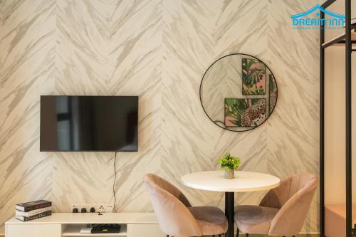a dining room with a table and a tv on a wall at Paxtonz Empire City Damansara Petaling Jaya by Dream Inn in Petaling Jaya