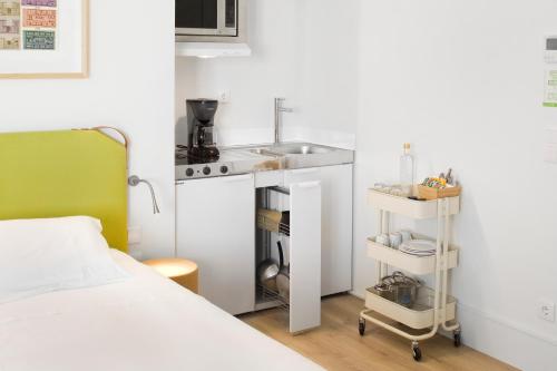 a small kitchen with a sink and a bed at LSA Ascensor da Bica by Numa in Lisbon