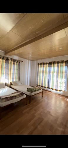 a large room with two beds and two windows at Sky land guest house in Leh