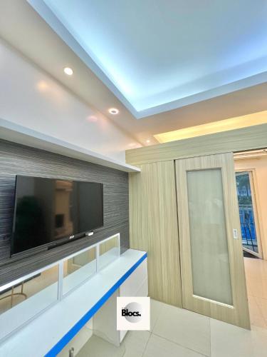 a living room with a flat screen tv on a wall at Direct to pool unit Shore Residences Condominium MOA Complex in Manila
