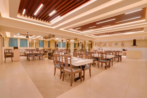 a large dining room with tables and chairs at Lemon Tree Hotel, Erode in Erode