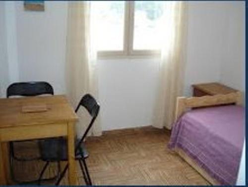 
a bedroom with a bed and a desk at Mar del Faro in Mar del Plata
