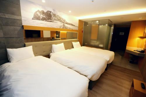 a hotel room with two beds and a kitchen at Asia Jeju in Jeju