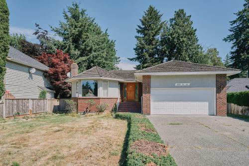 a house with a garage in a yard at The Coastal Garden Retreat in Delta