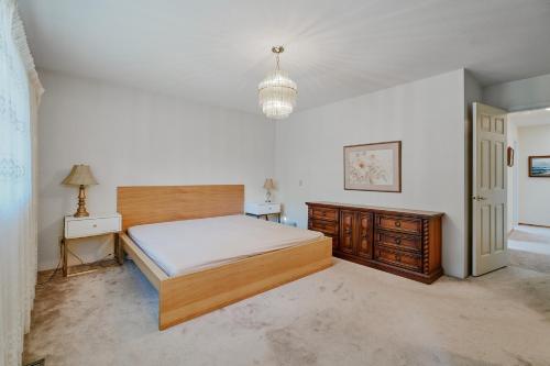 sypialnia z łóżkiem, komodą i lampą w obiekcie Tsawwassen 3 Bedroom Ground Suite w mieście Delta