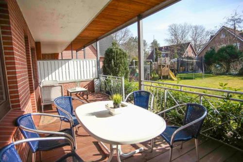 a patio with a white table and chairs on a balcony at Ferienwohnung Wieben in Sankt Peter-Ording