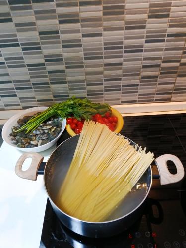 a pan filled with pasta on top of a stove at TIVA' Holiday House in Pozzuoli
