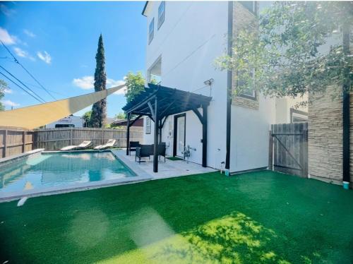 a house with a swimming pool with green grass at Relax in HTX POOL,15ppl,4br,4b in Houston