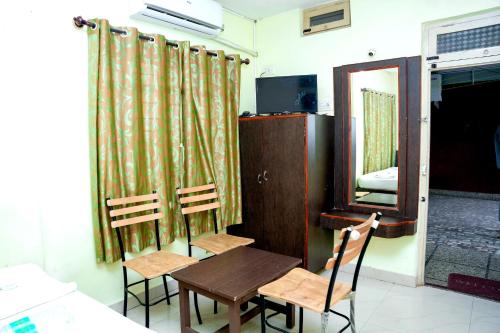 a room with a table and two chairs and a mirror at Vishnu Residency in Chikmagalūr