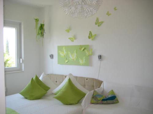 a living room with a couch and butterflies on the wall at Privathaus Marija in Dramalj