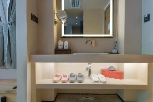 a bathroom with a sink and two pairs of shoes at Designer Bed and Breakfast Under the Green Trees in Lijiang