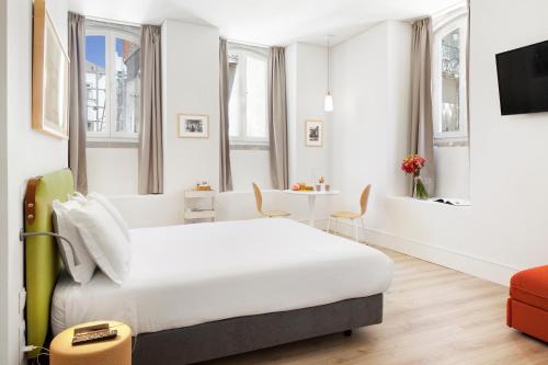 una habitación de hotel con una cama grande y una mesa en Ascensor da Bica - Lisbon Serviced Apartments en Lisboa
