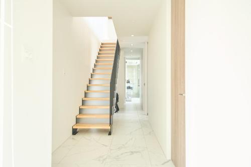 a staircase in a house with white walls at アナザーオーシャン淡路ヴィラ in Awaji