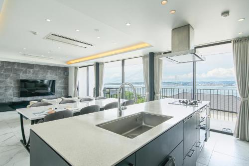 a kitchen with a sink and a living room at アナザーオーシャン淡路ヴィラ in Awaji