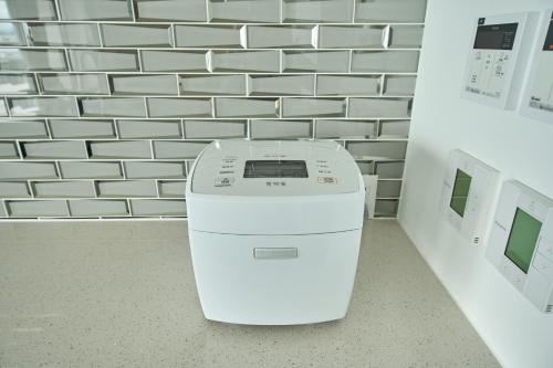 a washing machine in a room with a brick wall at アナザーオーシャン淡路ヴィラ in Awaji