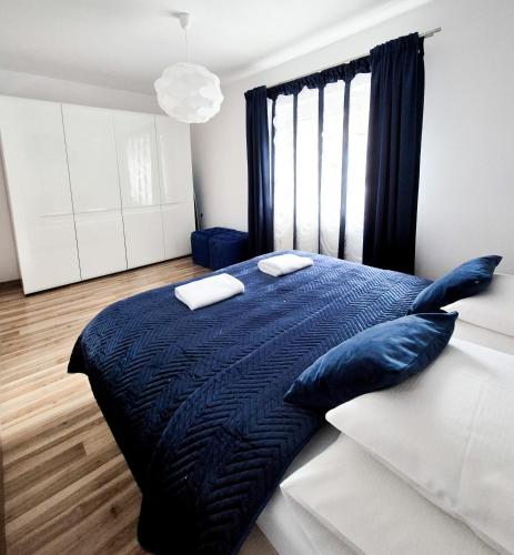 a bedroom with a large blue bed with blue pillows at Apartamenty Alcatraz z jacuzzi in Karpacz