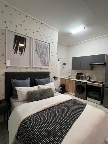a bedroom with a large bed and a kitchen at The Lagoon in Pretoria