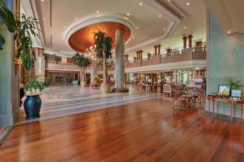a large lobby with wooden floors and potted plants at Sokha Angkor Resort in Siem Reap
