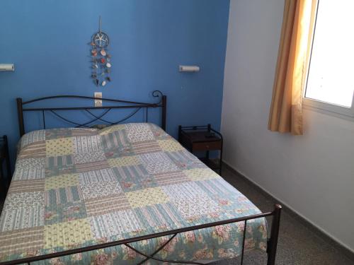 a bedroom with a bed with a quilt on it at Apostolakis Rooms in Agios Kirykos