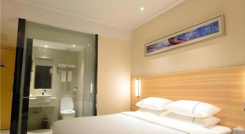 a hotel room with a bed and a bathroom at City Comfort Inn Wuhan Qingshan Jianshi Qingyiju Metro Station in Wuhan