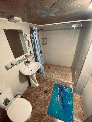 a bathroom with a dolphin shower and a sink at Elegant Hotel in Tashkent