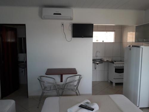 a kitchen with a table and two chairs and a refrigerator at Viking Flat in Praia do Frances