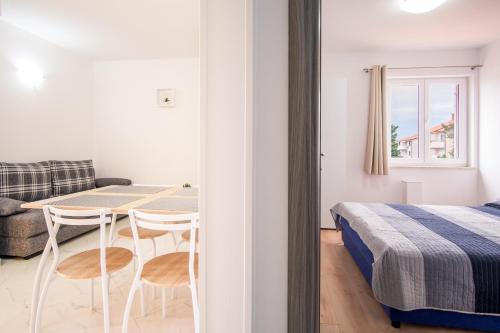 a bedroom with a bed and a table and chairs at Apartments VALL in Krk