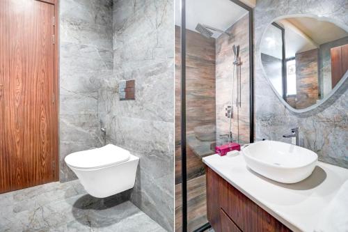 a bathroom with a toilet and a sink and a mirror at Sunday Premium 5 BHK Villa Mihika, Shimla in Shimla
