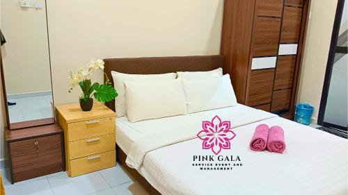 a bedroom with a bed with a pink cala sign on it at INAP DESA Homestaycation Kuantan - 5 minutes from Balok Beach by PG Management in Kampong Tanjong