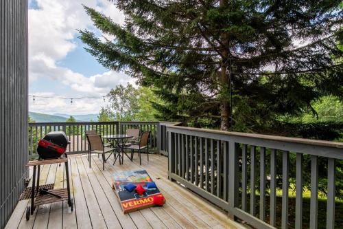 a deck with a table and chairs and a tree at Clyde's Cabin home in Warren