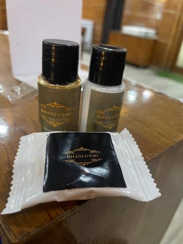 two bottles ofodorizers sitting on a wooden table at Hotel Dhan Luxmi in Tārna