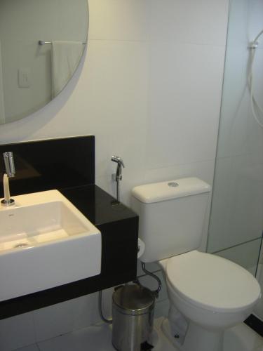 a bathroom with a white toilet and a sink at Bianca Praia Hotel in Recife