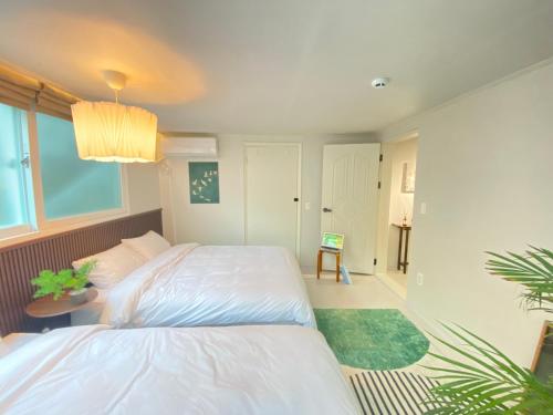 a bedroom with a white bed and a green rug at Stay in EV in Seoul